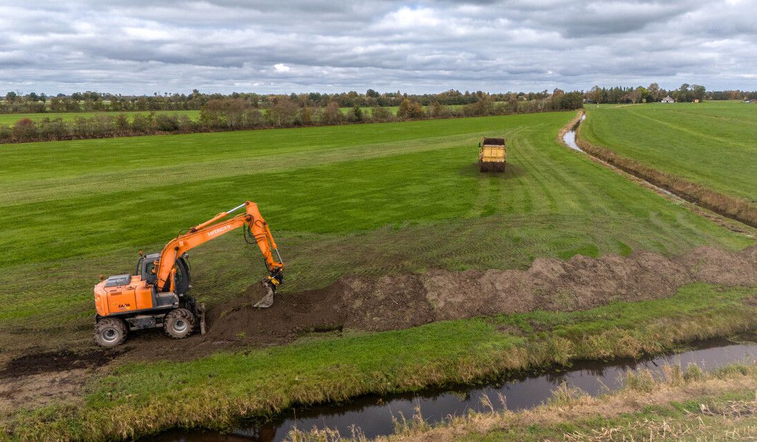 Luchtfoto van het perceel met op de voorgrond een kraan en in de achtergrond de rijdende meststrooier